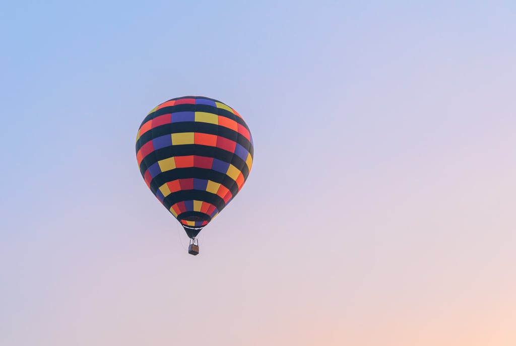 Hot air balloon flying on sky at sunset